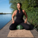 A female doing meditation next to the river sitting on the meditation cushion zafu and the yoga mat Cosmic Harmony Cork Yoga Mat cork yoga mat