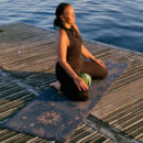 A female meditating sitting on meditation cushion zafu and a cork yoga mat 4 Cosmic Harmony Cork Yoga Mat cork yoga mat