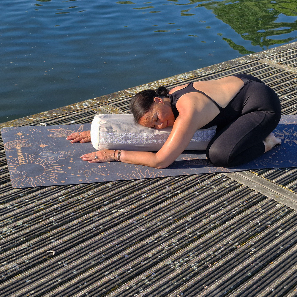 a female exercising yin yoga on the cork mat using yoga bolster 2 Cosmic Harmony Cork Yoga Mat cork yoga mat